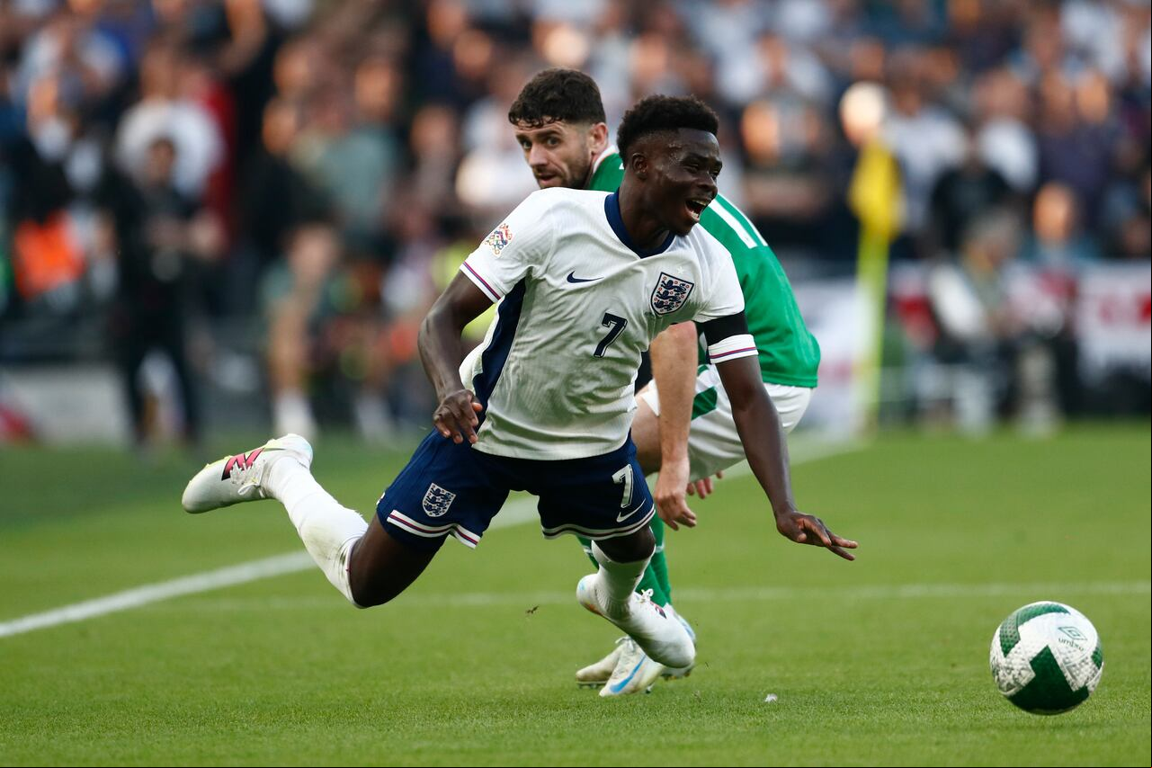 El irlandés Robbie Brady (derecha) comete una falta contra el inglés Bukayo Saka y luego recibe una tarjeta amarilla por la falta durante el partido de fútbol de la Liga de Naciones de la UEFA entre Irlanda e Inglaterra en el estadio Aviva en Dublín, Irlanda, el sábado 7 de septiembre de 2024. (Foto AP/Peter Morrison)