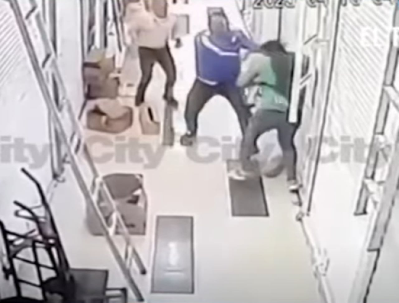 Mientras los dos sujetos se agreden, un tercer hombre, vestido con camisa amarilla, intenta intervenir para detener la pelea.
