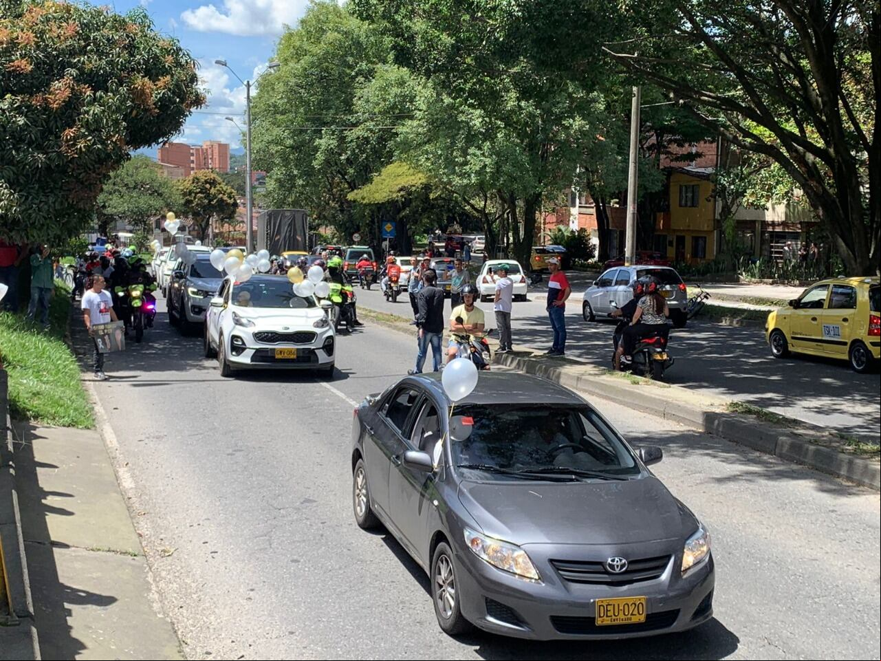 Una caravana acompaña la carroza fúnebre.