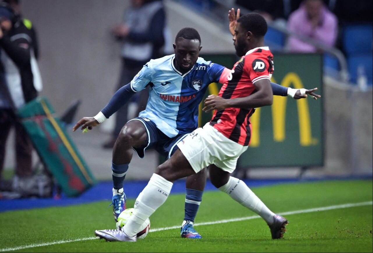 El defensor senegalés de Le Havre #93 Arouna Sangante (L) lucha por el balón con el delantero marfileño de Niza #07 Jeremie Boga durante el partido de fútbol francés L1 entre Le Havre AC y OGC Nice en el Stade Oceane en Le Havre, noroeste de Francia, el 16 de diciembre de 2023. (Foto de Lou Benoist / AFP)