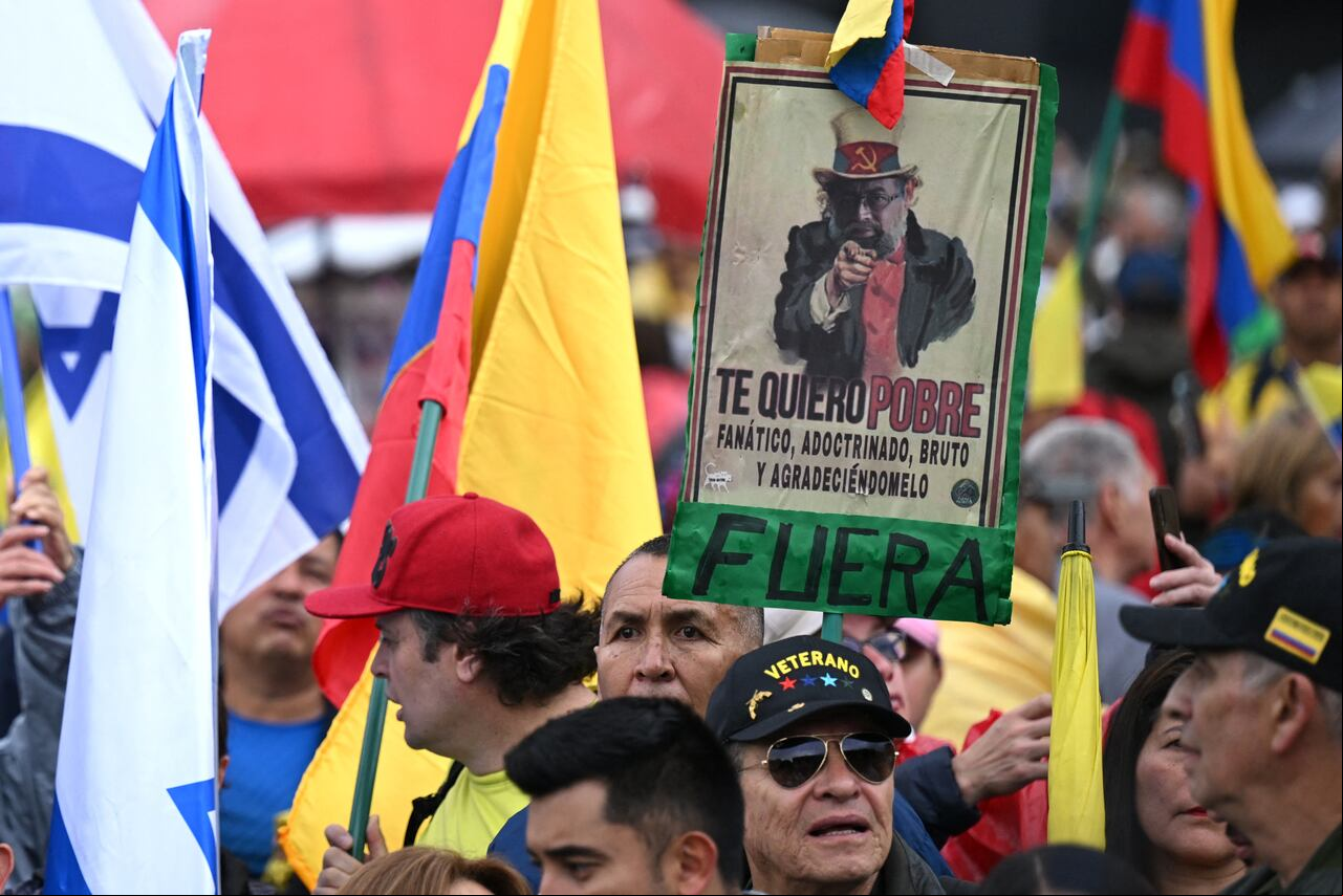 Un manifestante sostiene un cartel que representa al presidente colombiano Gustavo Petro que dice "Te quiero pobre, intolerante, adoctrinado, tonto y que me agradezcas" durante una marcha contra el gobierno de Petro por las reformas de salud y pensiones en Bogotá el 21 de abril de 2024. Cientos De miles de personas protestan este domingo en las principales ciudades de Colombia, en la mayor manifestación que enfrenta el gobierno de Gustavo Petro desde que llegó al poder hace veinte meses y en un momento en el que su popularidad está en números rojos. (Foto de Raúl ARBOLEDA / AFP)