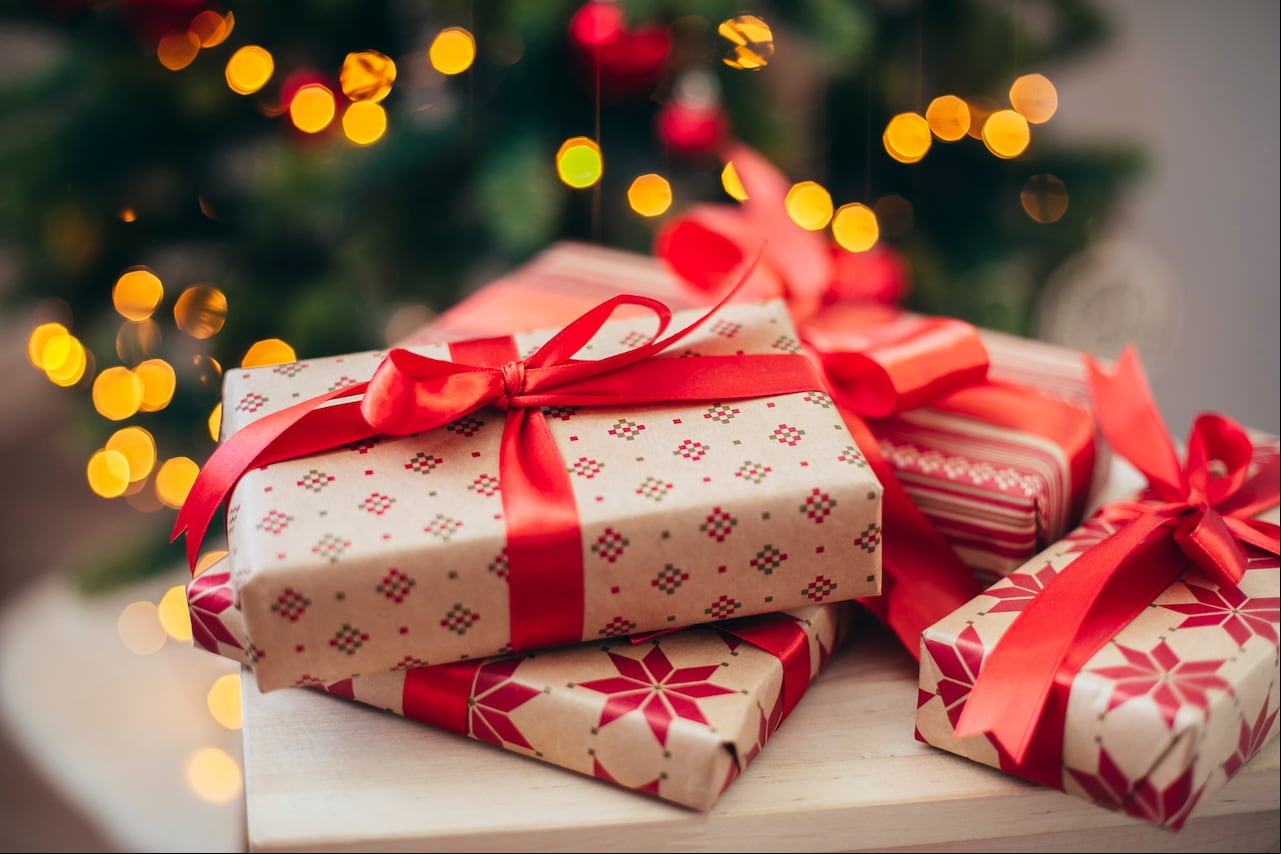 Beautiful Christmas gift boxes near fir tree. Merry Christmas and Happy New Year