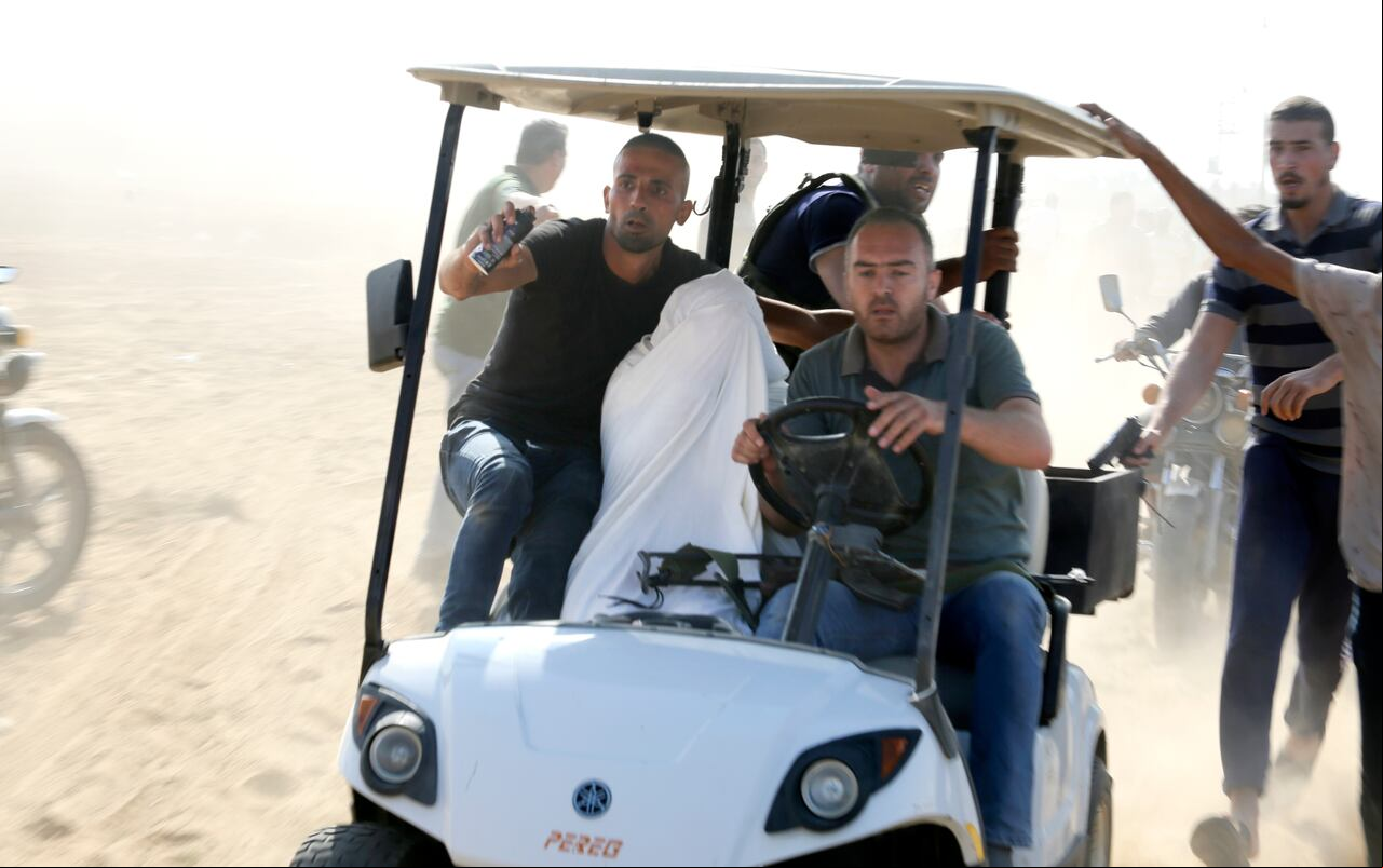 Los palestinos transportan a un civil israelí capturado desde el kibutz Kfar Azza a la Franja de Gaza