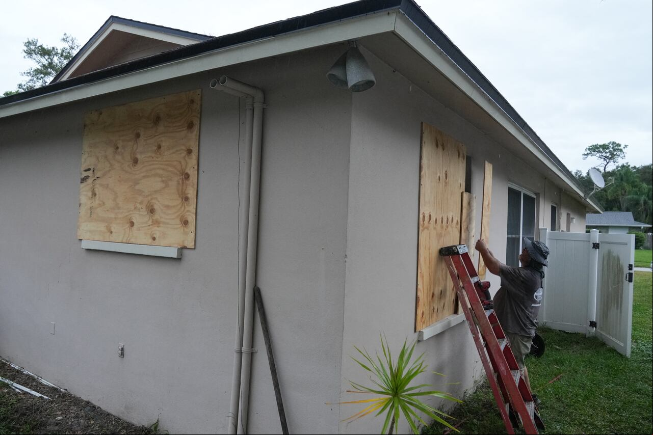 Un residente tapa sus ventanas con tablas en Palm Harbor, Florida, antes de la llegada prevista del huracán Milton a mitad de semana el 6 de octubre de 2024. Otra tormenta potencialmente devastadora azotó la costa de Florida el 6 de octubre