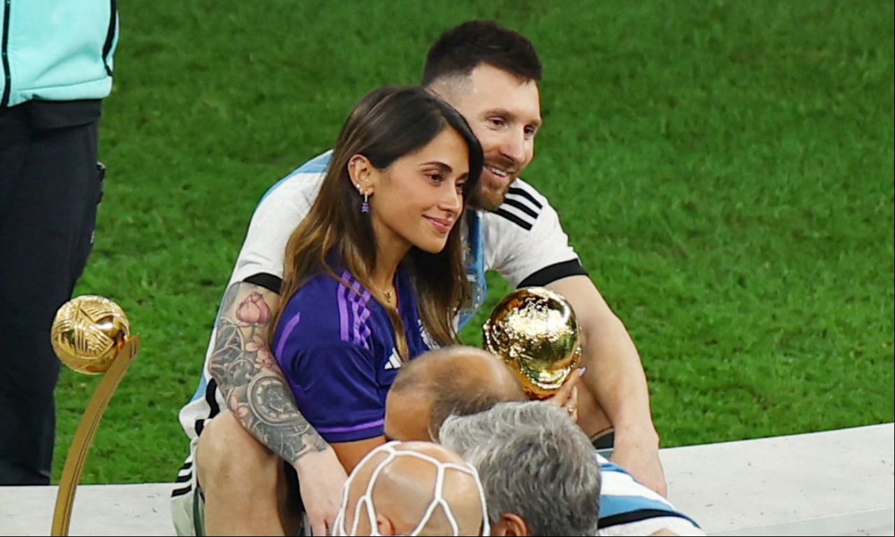 Soccer Football - FIFA World Cup Qatar 2022 - Final - Argentina v - Lusail Stadium, Lusail, Qatar - December 18, 2022 Argentina's Lionel Messi celebrates winning the World Cup with wife Antonela Roccuzzo holding the trophy REUTERS/Molly Darlington