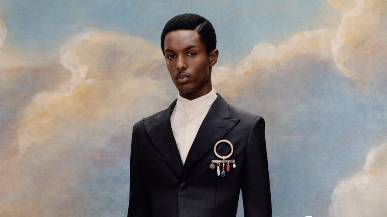 Hombre negro vestido con un traje de sastrería clásica en tonos oscuros, posando de pie sobre fondo neutro, como símbolo del estilo masculino negro que inspira la Met Gala 2025.