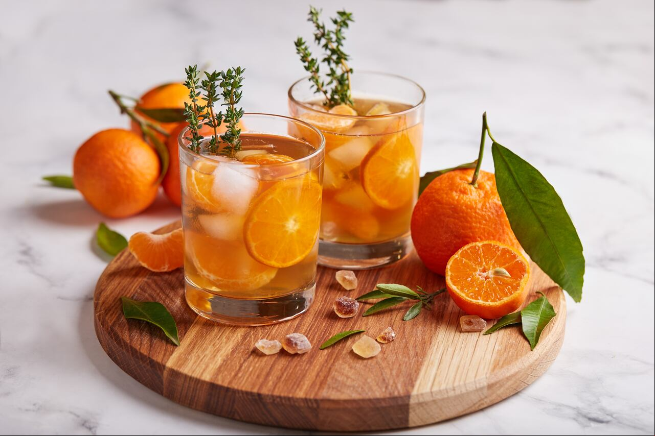 Ice tea with orange juice, ice cubes, and thymes. Refreshed cold spring and summer citrus beverage.