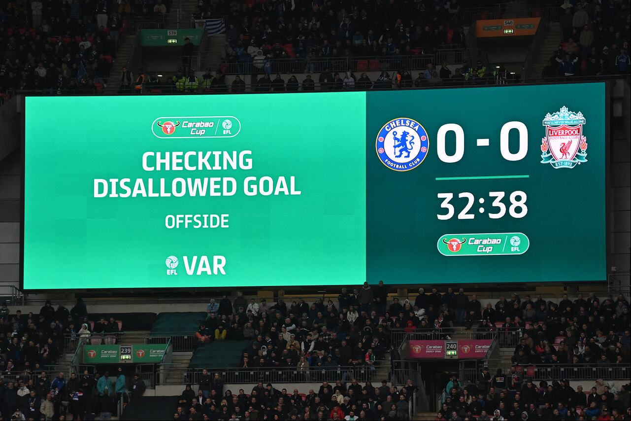 A giant screen displays the VAR review in to the disallowed goal by Chelsea's English midfielder #07 Raheem Sterling during the English League Cup final football match between Chelsea and Liverpool at Wembley stadium, in London, on February 25, 2024. (Photo by Glyn KIRK / AFP) / RESTRICTED TO EDITORIAL USE. No use with unauthorized audio, video, data, fixture lists, club/league logos or 'live' services. Online in-match use limited to 120 images. An additional 40 images may be used in extra time. No video emulation. Social media in-match use limited to 120 images. An additional 40 images may be used in extra time. No use in betting publications, games or single club/league/player publications. /