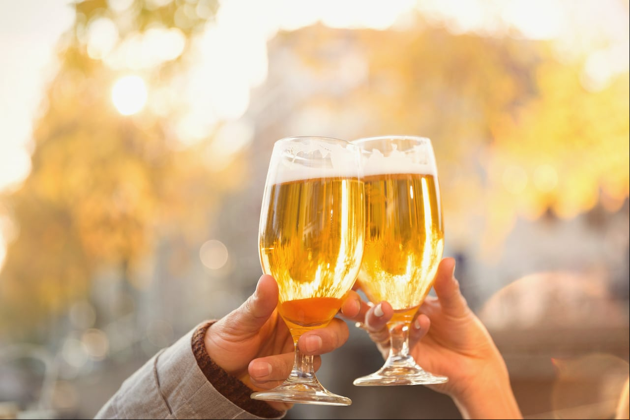 Pareja brindando con vasos de cerveza