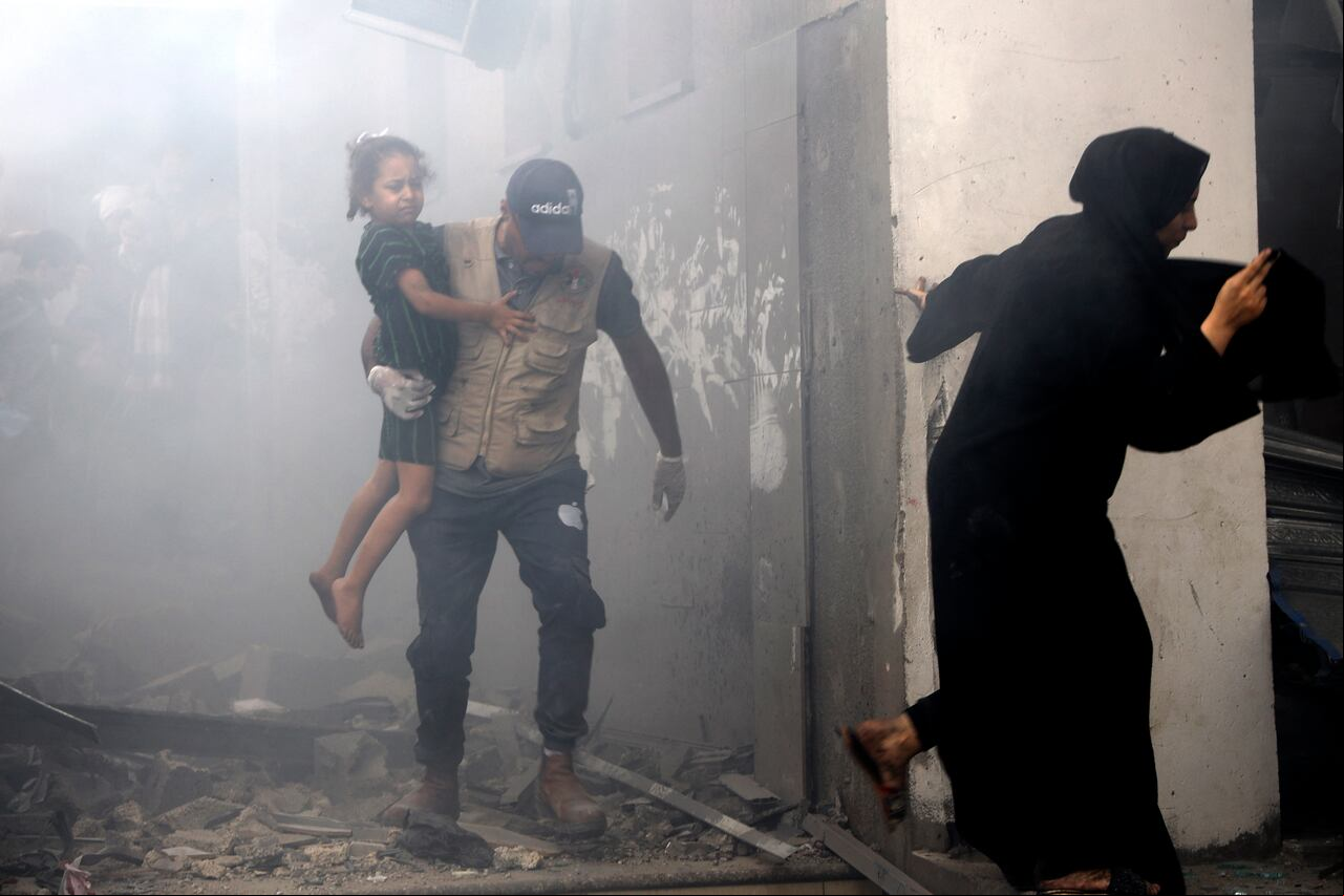 de una familia palestina salen corriendo de una casa bombardeada durante los ataques aéreos israelíes en la ciudad de Gaza el 9 de octubre de 2023.