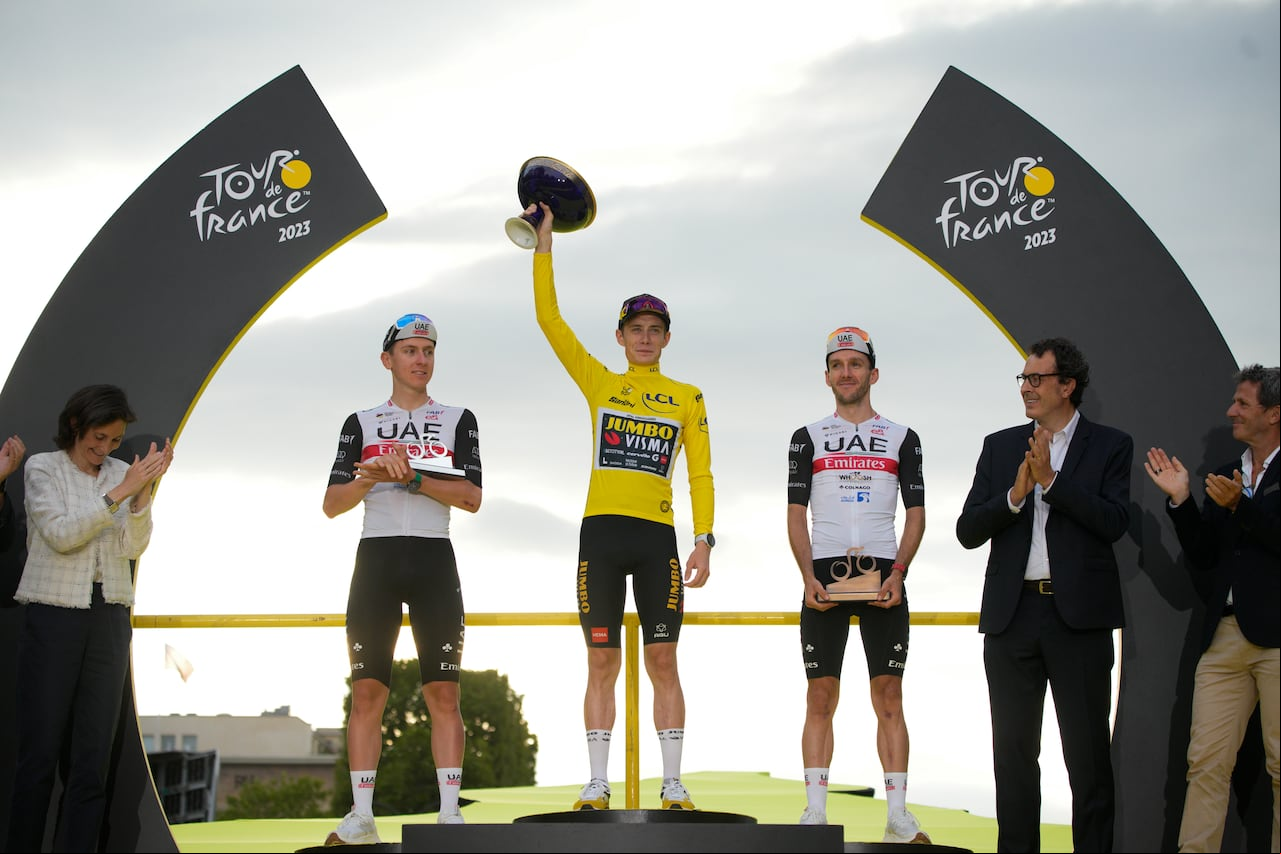 El ganador del Tour de Francia, el danés Jonas Vingegaard, con el maillot amarillo de líder general, el segundo clasificado, el esloveno Tadej Pogacar, a la izquierda, y el tercer clasificado, el británico Adam Yates, a la derecha, celebran en el podio después de la vigésima primera etapa de la carrera ciclista del Tour de Francia de más de 115 kilómetros (71,5 millas) con inicio en Saint-Quentin-en-Yvelines y final en la avenida Champs-Elysees en París, Francia, el domingo 23 de julio de 2020. 23. (Foto AP/Daniel Cole)