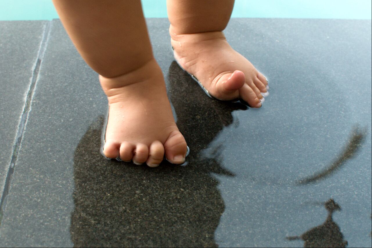 Pies de bebé cerca a piscina