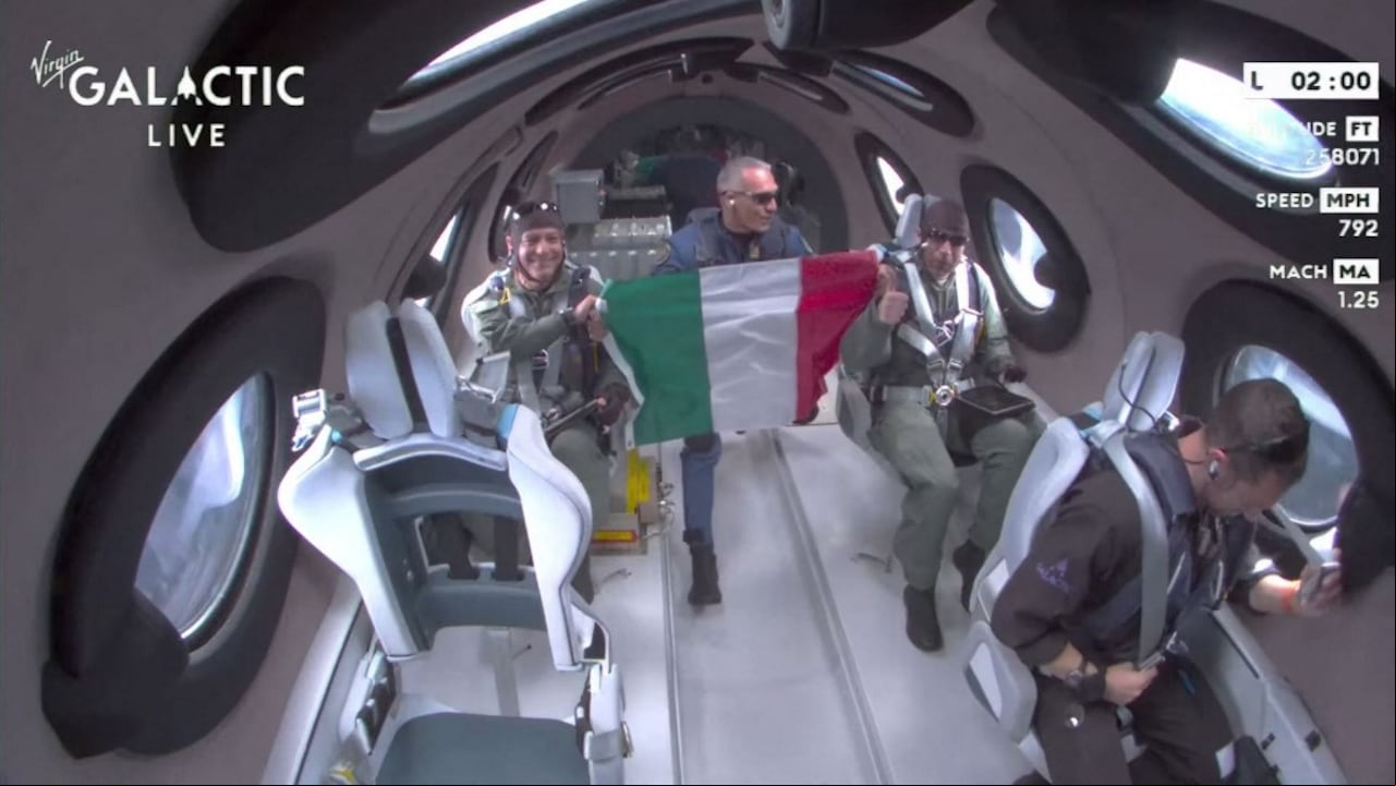 This still image from a Virgin Galactic video shows Galactic 01 mission crew from the Italian Air Force display the Italian flag as they reach space during the first commercial flight from Spaceport City in New Mexico on June 29, 2023. Virgin Galactic on June 29 began commercial spaceflights, a major milestone for the company founded in 2004 by British billionaire Richard Branson. Its first paying customers are a three-member crew from the Italian Air Force and National Research Council of Italy, with a fourth seat occupied by a Virgin Galactic astronaut instructor. (Photo by Handout / Virgin Galactic / AFP) / RESTRICTED TO EDITORIAL USE - MANDATORY CREDIT "AFP PHOTO / Virgin Galactic" - NO MARKETING NO ADVERTISING CAMPAIGNS - DISTRIBUTED AS A SERVICE TO CLIENTS