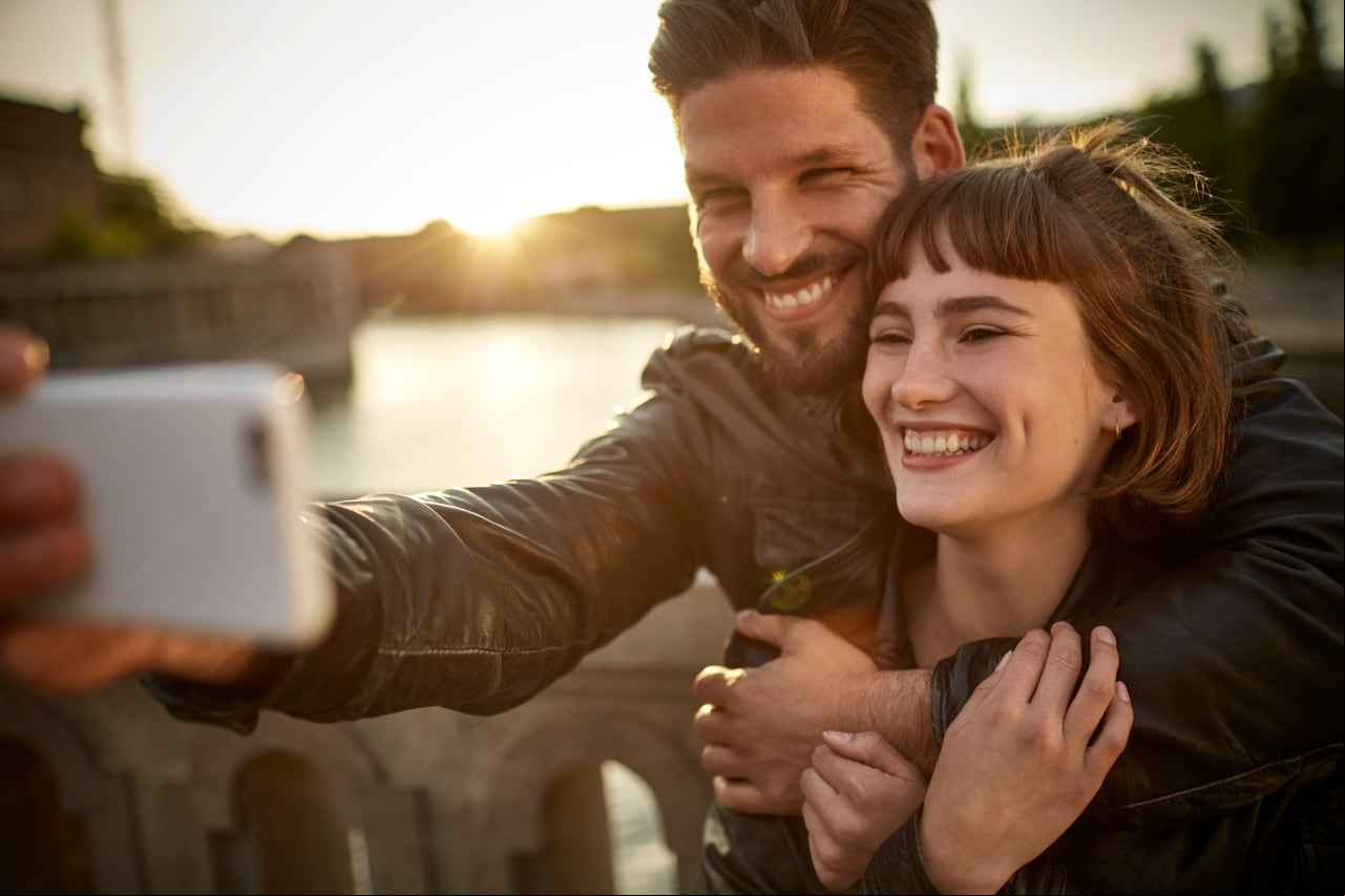 Joven pareja tomándose una selfie en medio de un viaje
