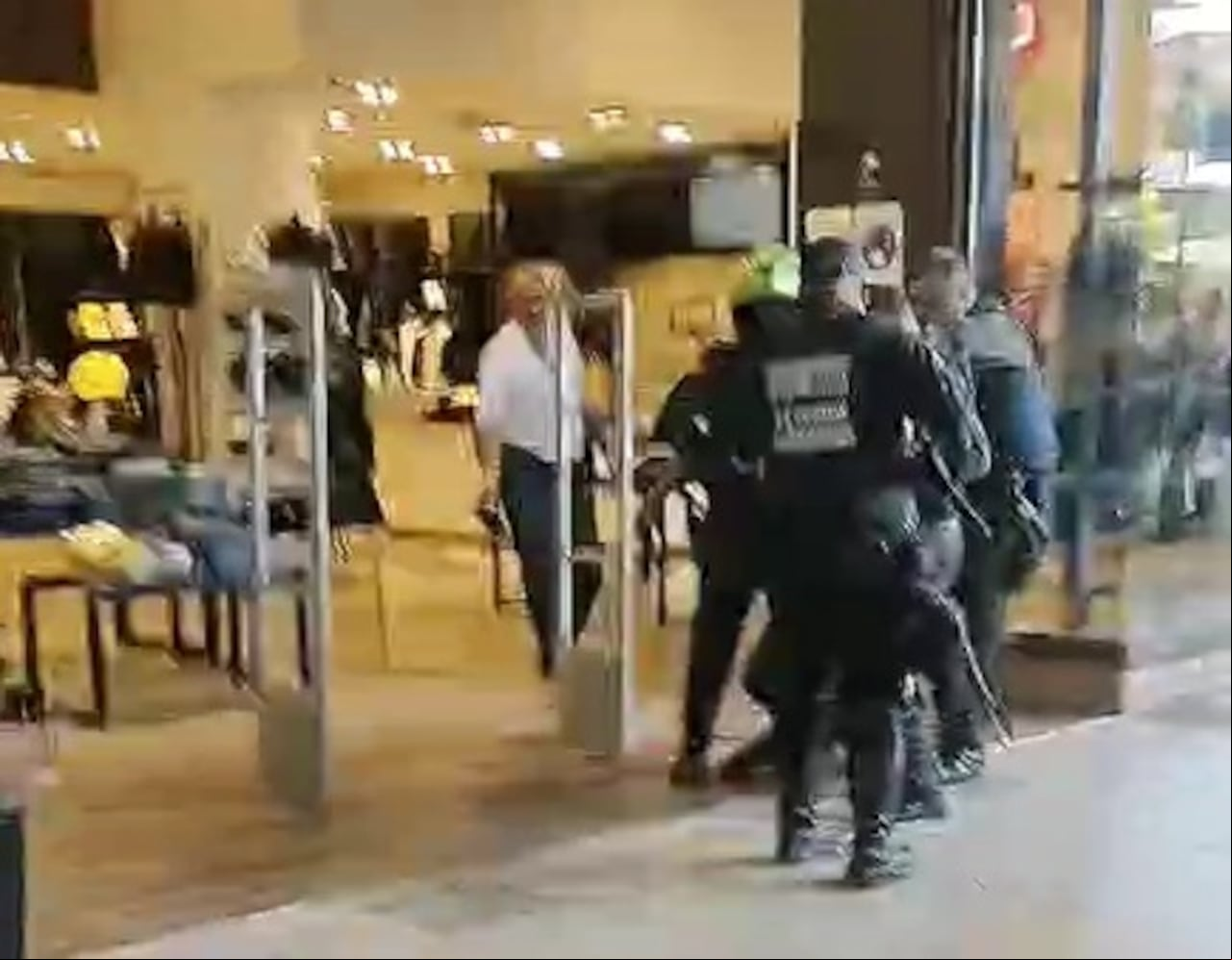 Personal de seguridad y policías ayudan al trasladado del agresor a un centro asistencial luego de fallar en su intención de poner fin a su vida tras lesionar a una mujer, su excompañera sentimental.