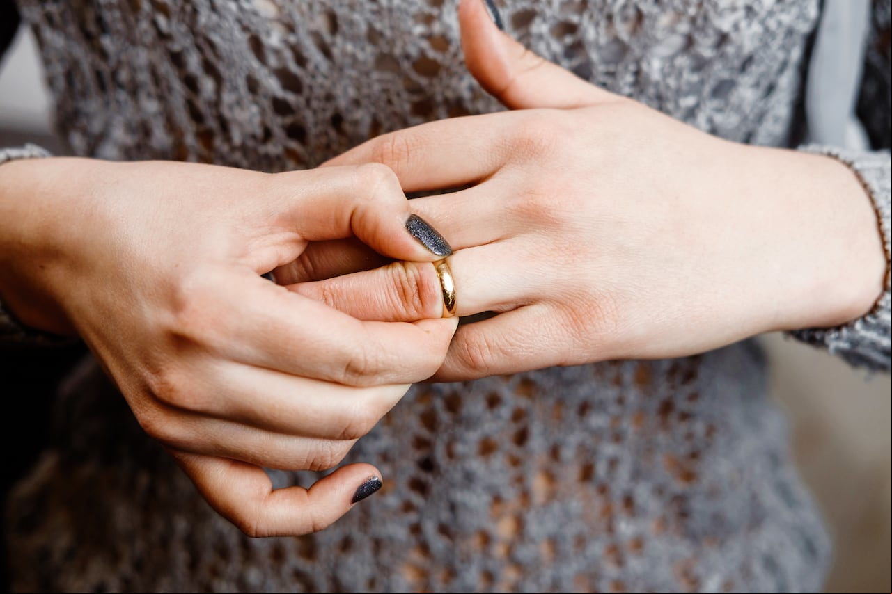 Una mujer se quita un anillo de compromiso, conflicto familiar, primer plano