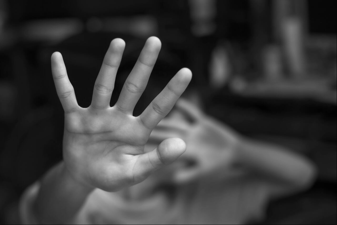 Boy showing STOP gesture with his hand.