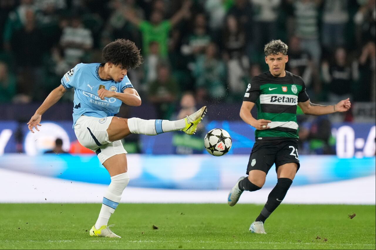 Rico Lewis del Manchester City patea el balón frente a Maximiliano Araujo del Sporting durante el partido de apertura de la Liga de Campeones de la UEFA entre el Sporting y el Manchester City en Lisboa, Portugal, el martes 5 de noviembre de 2024. (Foto AP/Armando Franca)