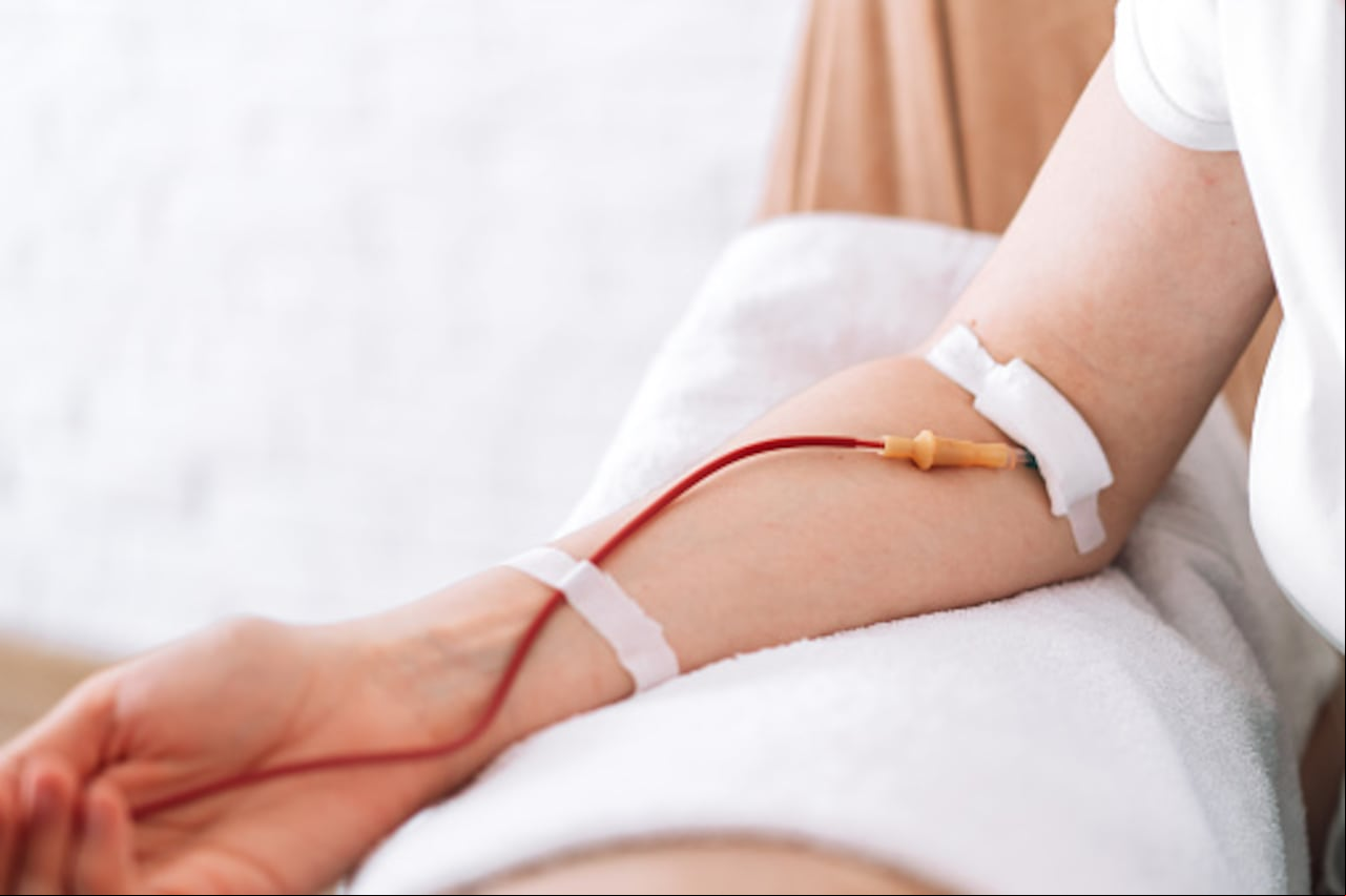 Girl sitting in chair donates blood.