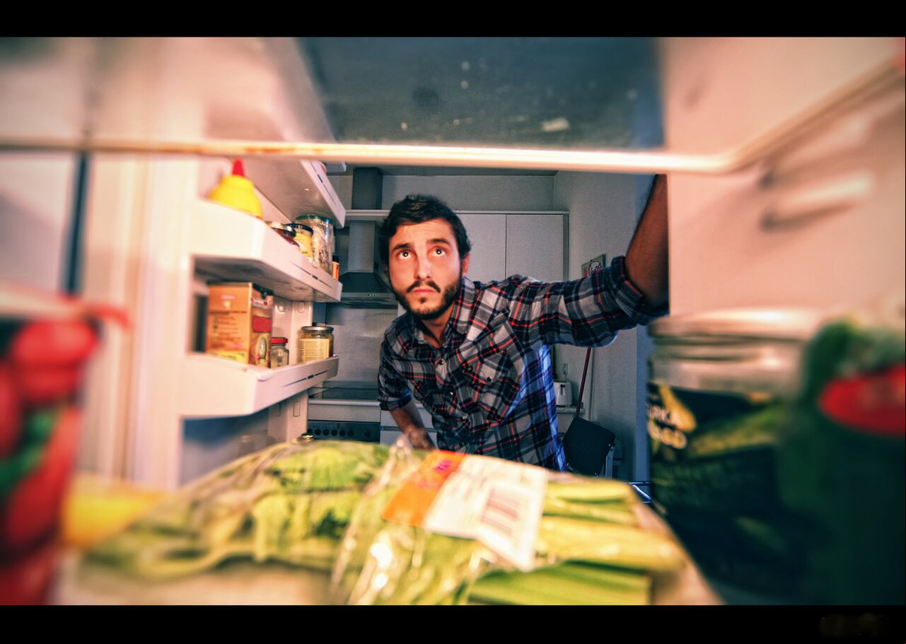 Man looking in refrigerator to find something.