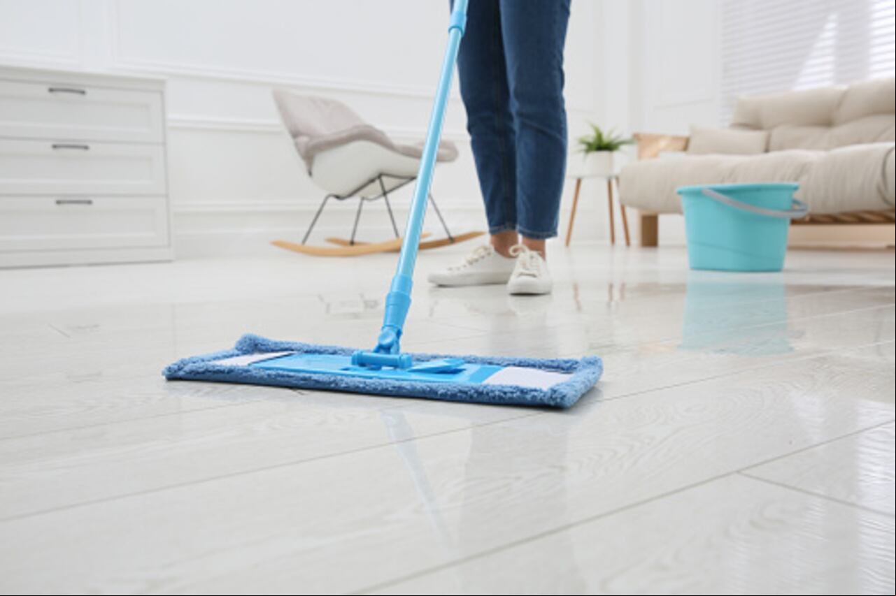 Pies de mujer haciendo limpieza en una casa