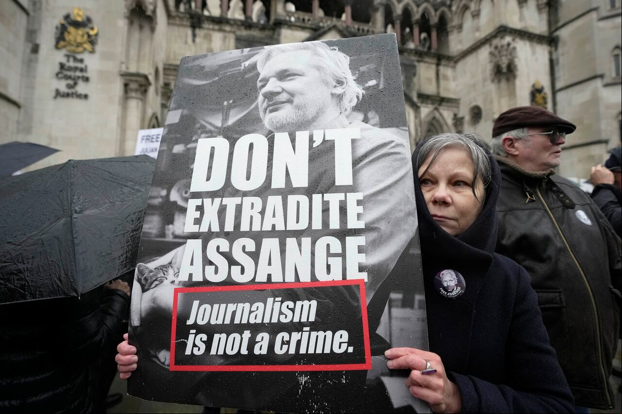 Un manifestante sostiene una pancarta frente a los Tribunales Reales de Justicia en Londres, el miércoles 21 de febrero de 2024.