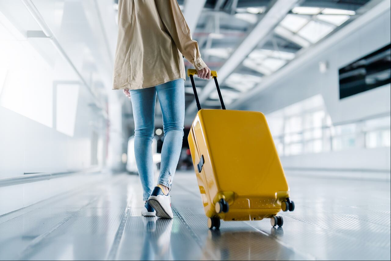 Terminal del aeropuerto internacional. Mujer con equipaje y caminando en el aeropuerto